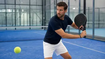 Padelspiller med et perforeret bat i klar position